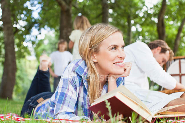 Woman reading on blanket in park — Stock Photo