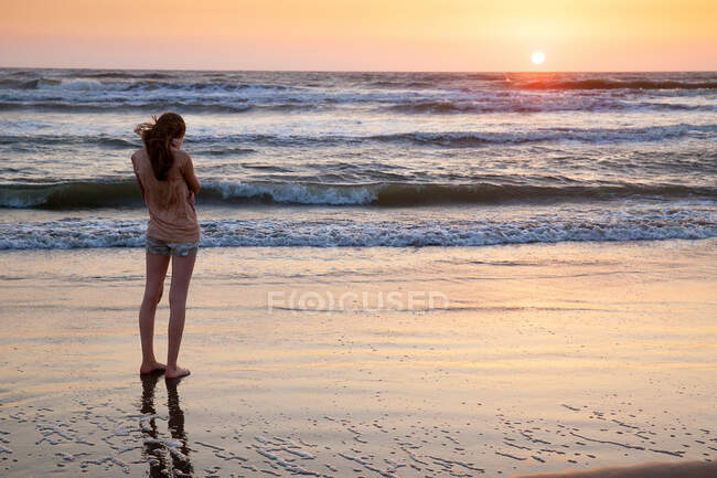 Ragazza in piedi sulla spiaggia — Foto stock