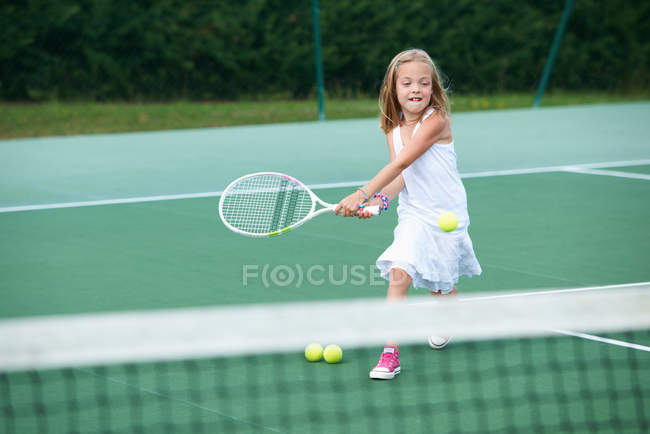 Chica jugando tenis en la cancha - foto de stock