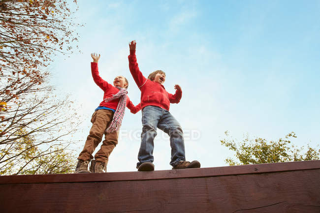 Children balancing on wooden wall — Stock Photo