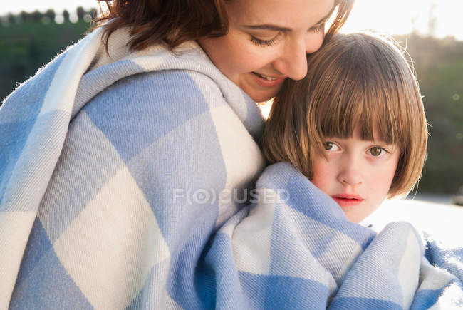 Mãe e filha envoltas em cobertor — Fotografia de Stock