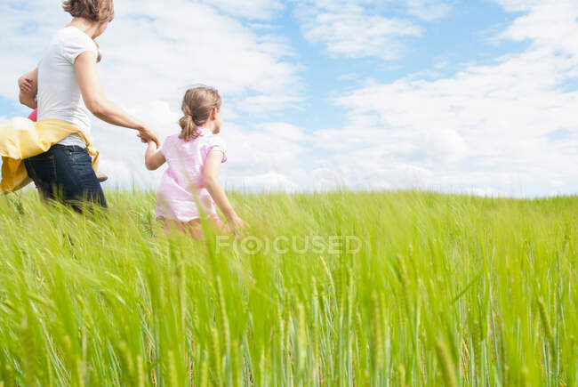 Mãe com duas filhas no campo — Fotografia de Stock