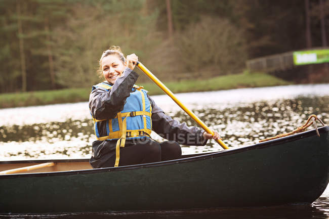 Donna canoa a remi sul lago ancora — Foto stock