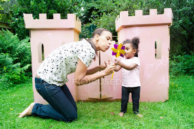 Mother and daughter blowing pinwheel — Stock Photo