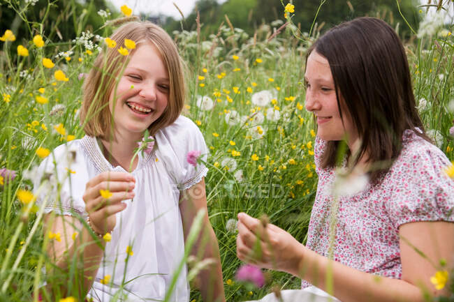 Girls in meadow with flowers — Stock Photo