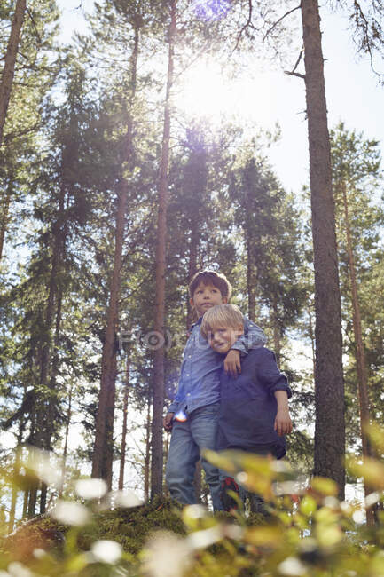 Brothers standing in forest with arm around — Stock Photo