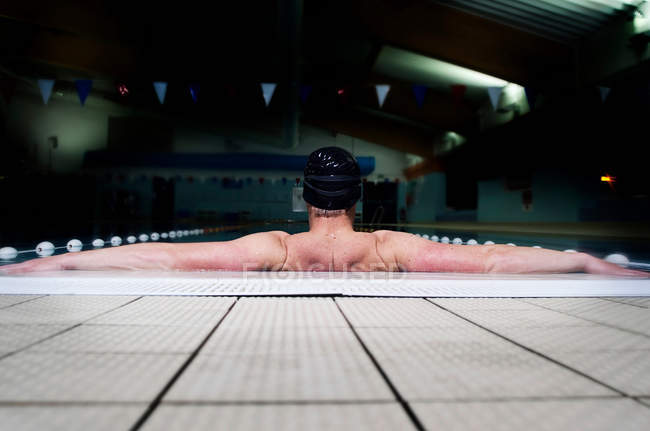 Hombre deportivo apoyado en la piscina - foto de stock