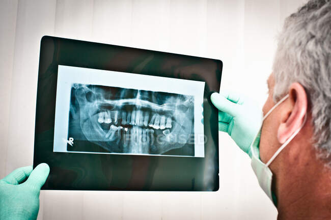 Dentiste examinant les radiographies dentaires — Photo de stock