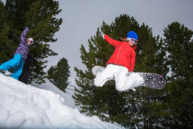 Snowboarder springt auf verschneiten Hang — Stockfoto