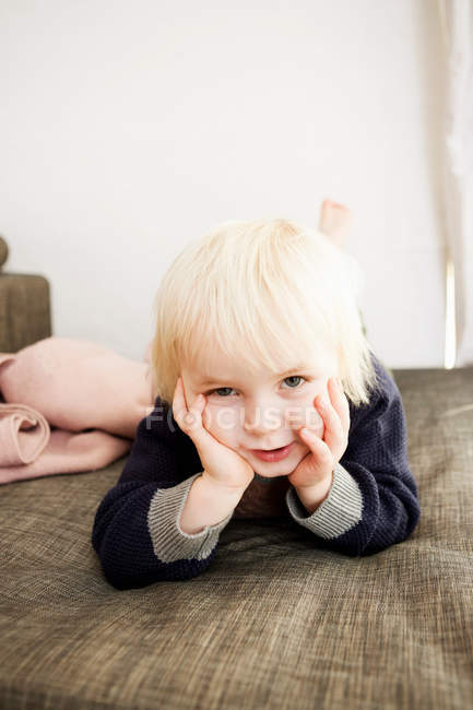 Smiling boy laying on bed — Stock Photo