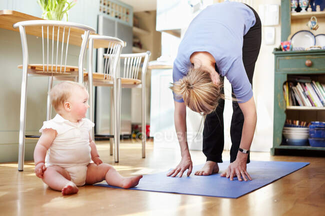 Mamma che fa yoga con un bambino — Foto stock