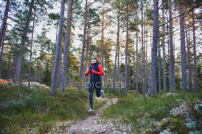 Frontansicht einer Frau, die im Wald läuft — Stockfoto