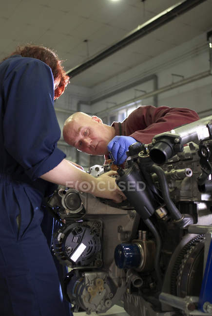 Teacher helping student with car engine — Stock Photo