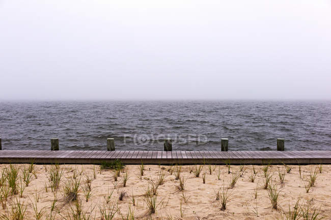 Морський пейзаж з пляжем і дерев'яною дошкою — стокове фото