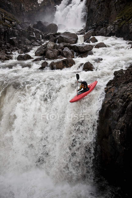 Homme faisant du canoë sur une cascade rocheuse — Photo de stock