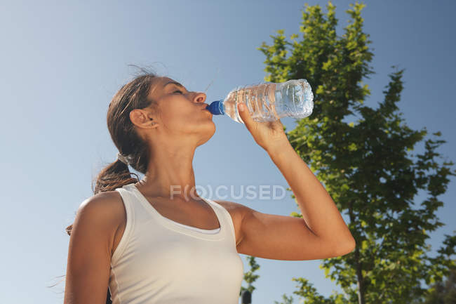Donna che beve acqua all'aperto — Foto stock