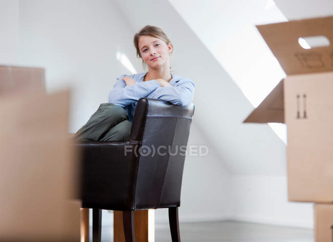 Mulher sentada na cadeira na nova casa — Fotografia de Stock