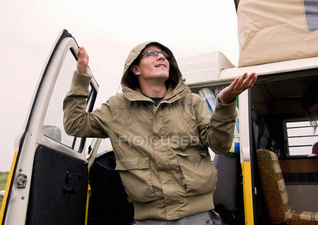 Male camper feeling for the rain — Stock Photo