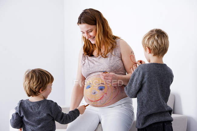 Kinder greifen auf schwangere Mutter zurück — Stockfoto