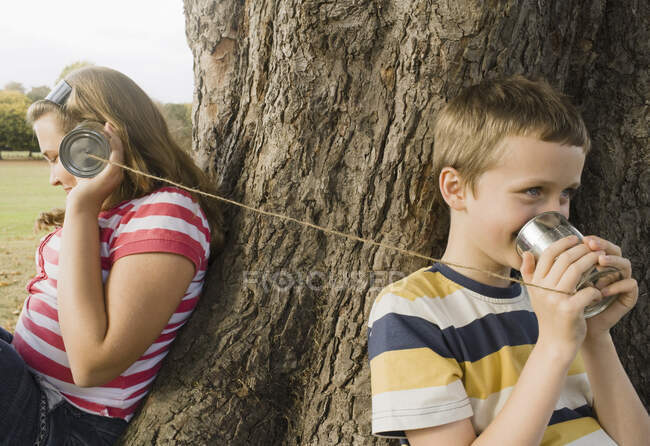 Miúdos com telefones da lata de estanho — Fotografia de Stock