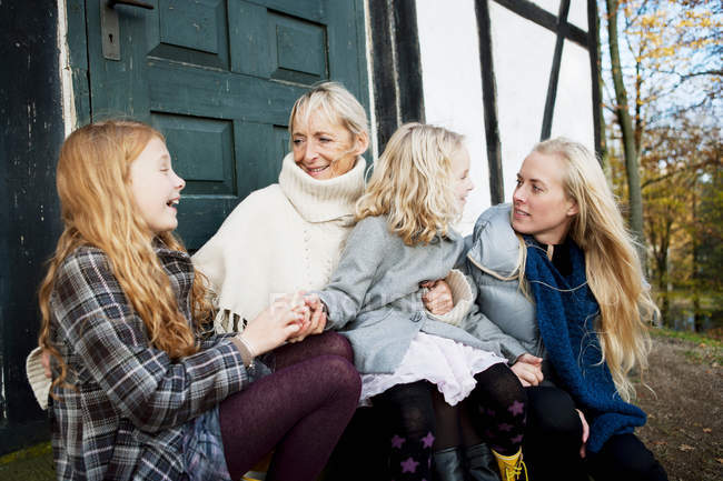 Mutter und Töchter sitzen draußen — Stockfoto