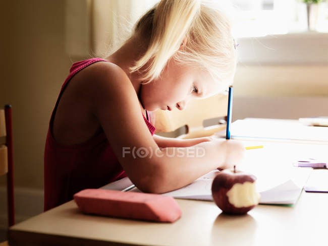Fille faire des devoirs au bureau — Photo de stock