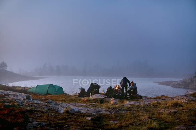 Randonneurs se relaxant dans un camp près du lac, Laponie, Finlande — Photo de stock
