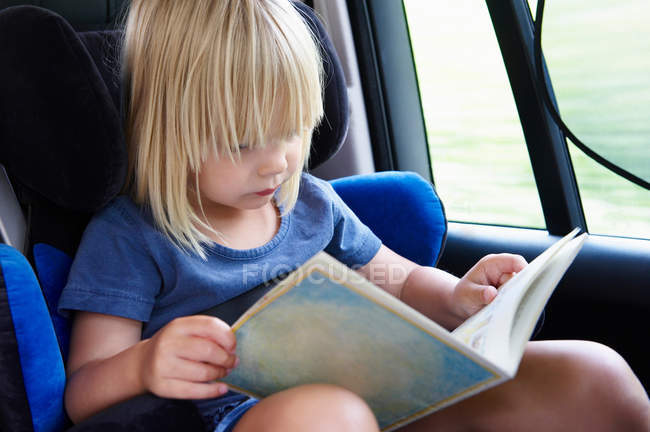 Petite fille lecture d'une carte dans la voiture — Photo de stock