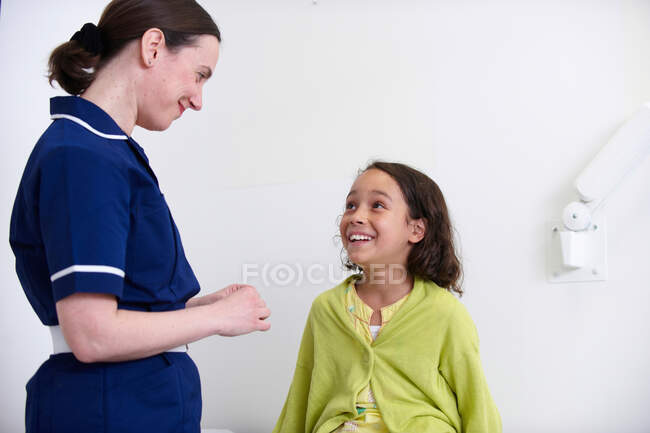 Enfermera y niña sonriendo - foto de stock