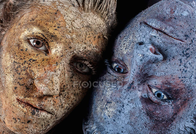 Cropped view of paint covered young women looking at camera — Stock Photo