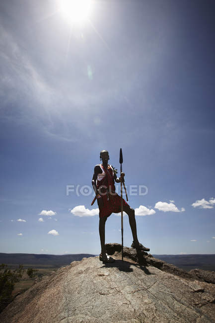 Масаи стоит на вершине скалы — стоковое фото