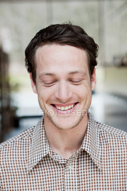 Hombre sonriendo con los ojos cerrados - foto de stock