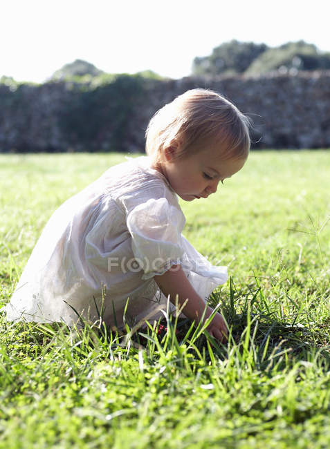 Fille jouer dans l'herbe haute — Photo de stock