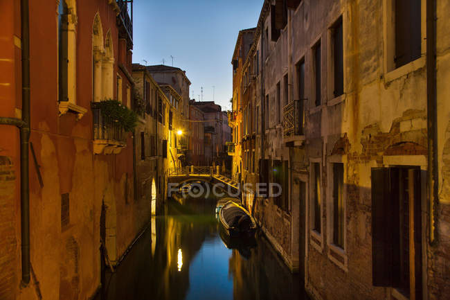 Rowboat and buildings on urban canal — Stock Photo