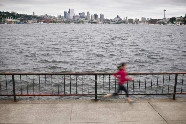 Blurred view of runner by waterfront — Stock Photo