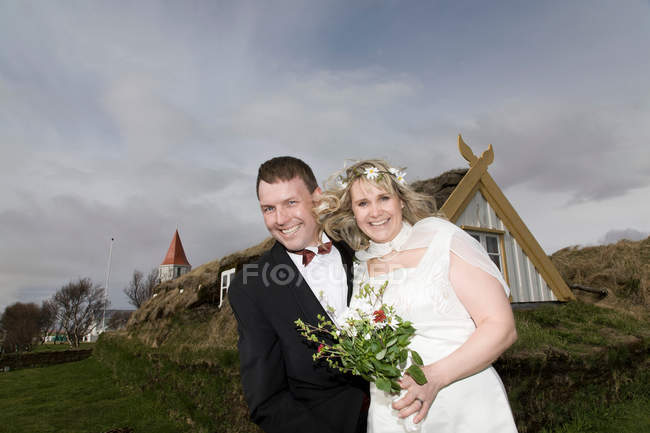 Couple jeune marié souriant dans le champ — Photo de stock