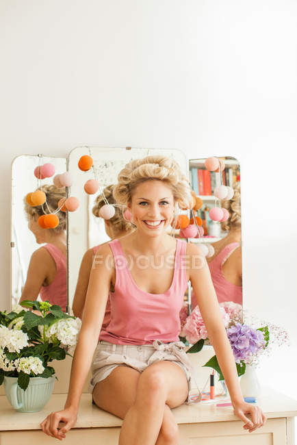 Mulher sorridente sentada na vaidade — Fotografia de Stock