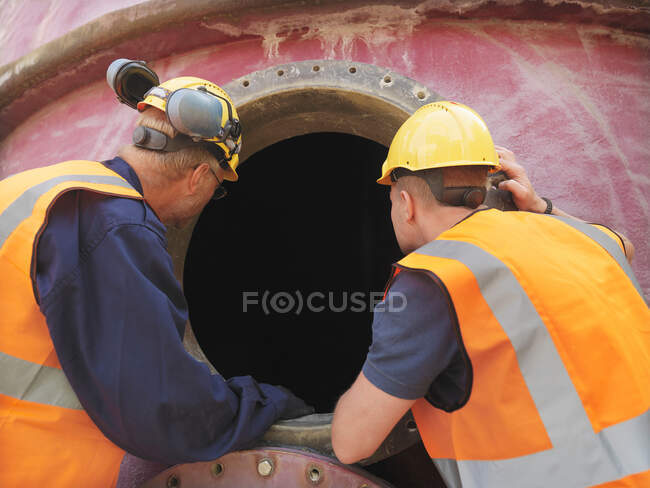 Workers examining machinery on site — Stock Photo