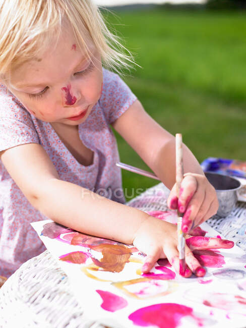 Pittura bambina in un campo verde — Foto stock