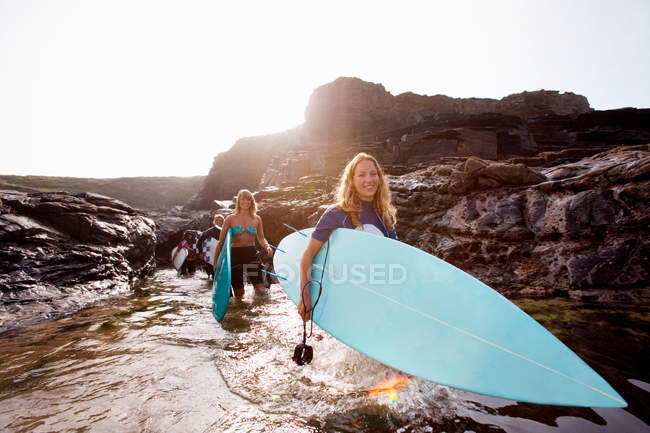 Quattro persone che trasportano tavole da surf — Foto stock