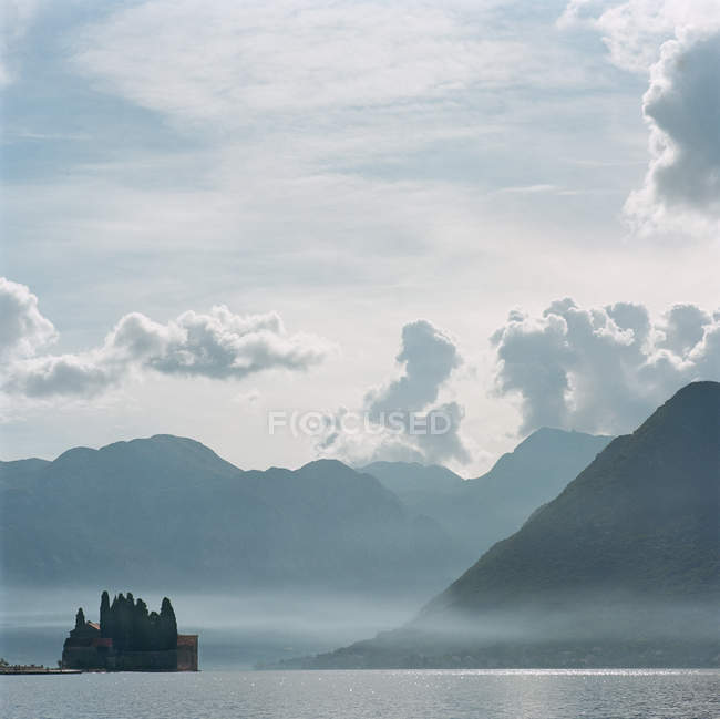 Castello e cime delle montagne sull'acqua — Foto stock
