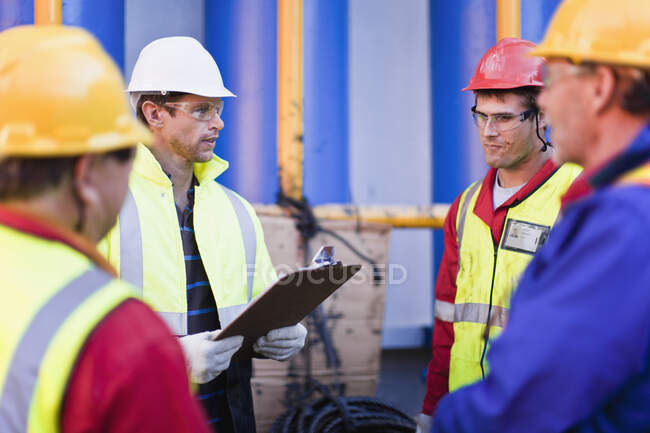 Trabajadores hablando en plataforma petrolera - foto de stock
