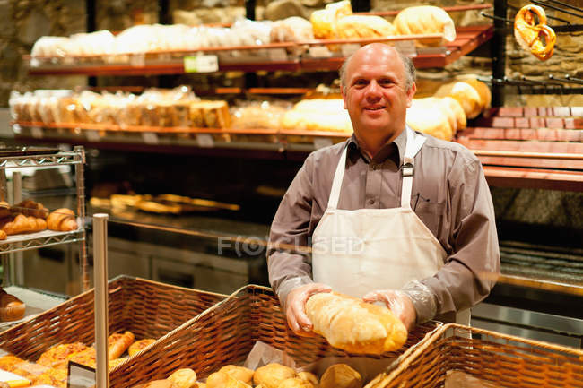 Lächelnder Bäcker mit Brotlaib — Stockfoto