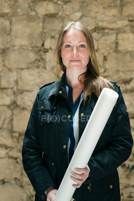 Woman carrying roll of paper indoors — Stock Photo