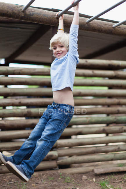 Boy swinging from monkey bars, selective focus — Stock Photo