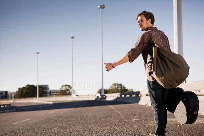 Young man hitch hiking — Stock Photo