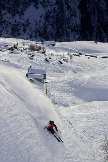 Лыжник зимой спускается по склону — стоковое фото