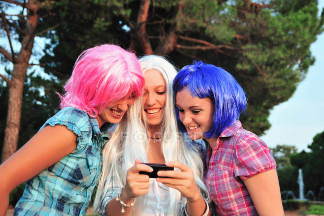 Teenage girls wearing colorful wigs — Stock Photo