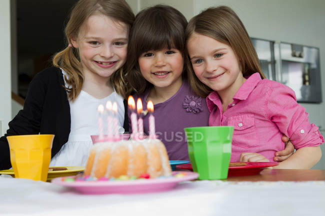 Lächelnde Mädchen umarmen sich bei Geburtstagsparty — Stockfoto