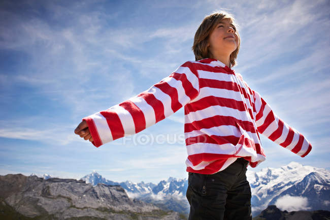 Boy standing in rocky landscape — Stock Photo